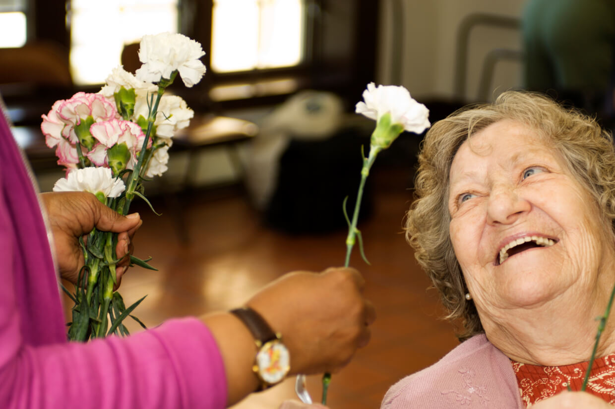Glückliche ältere Frau erhält Blumen